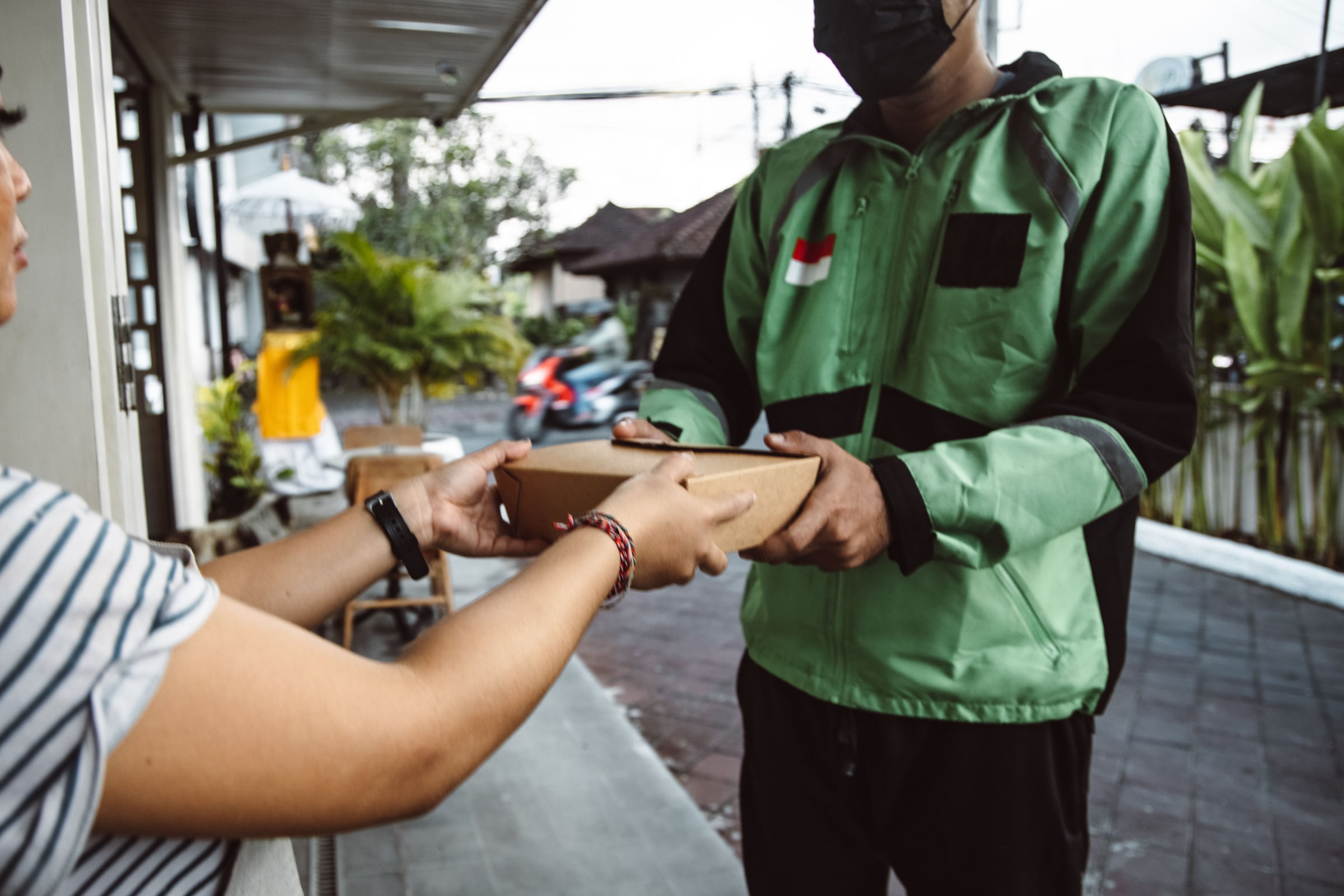 A rider handing over a parcel at a customer's door