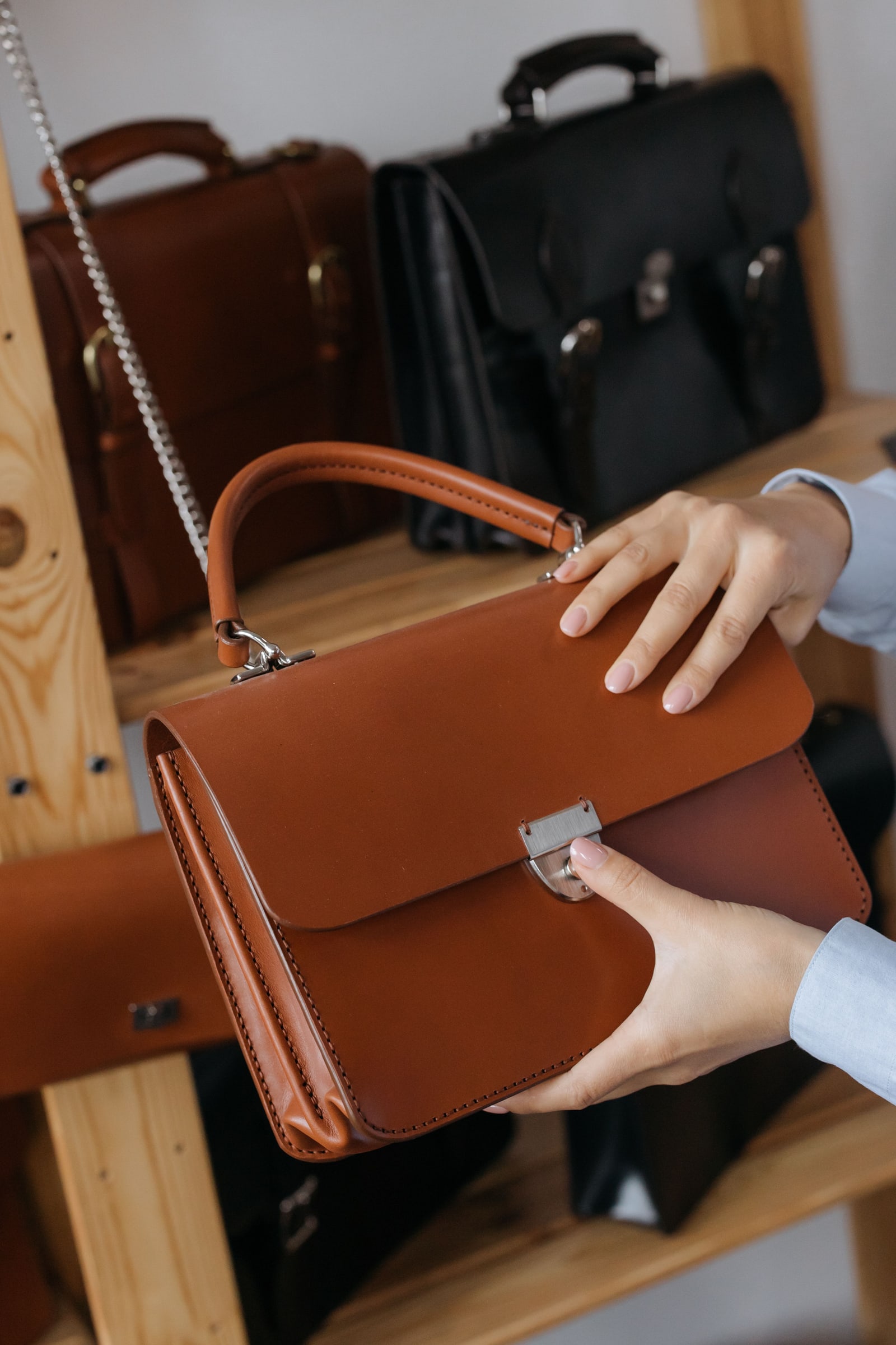 A brown leather handbag being opened