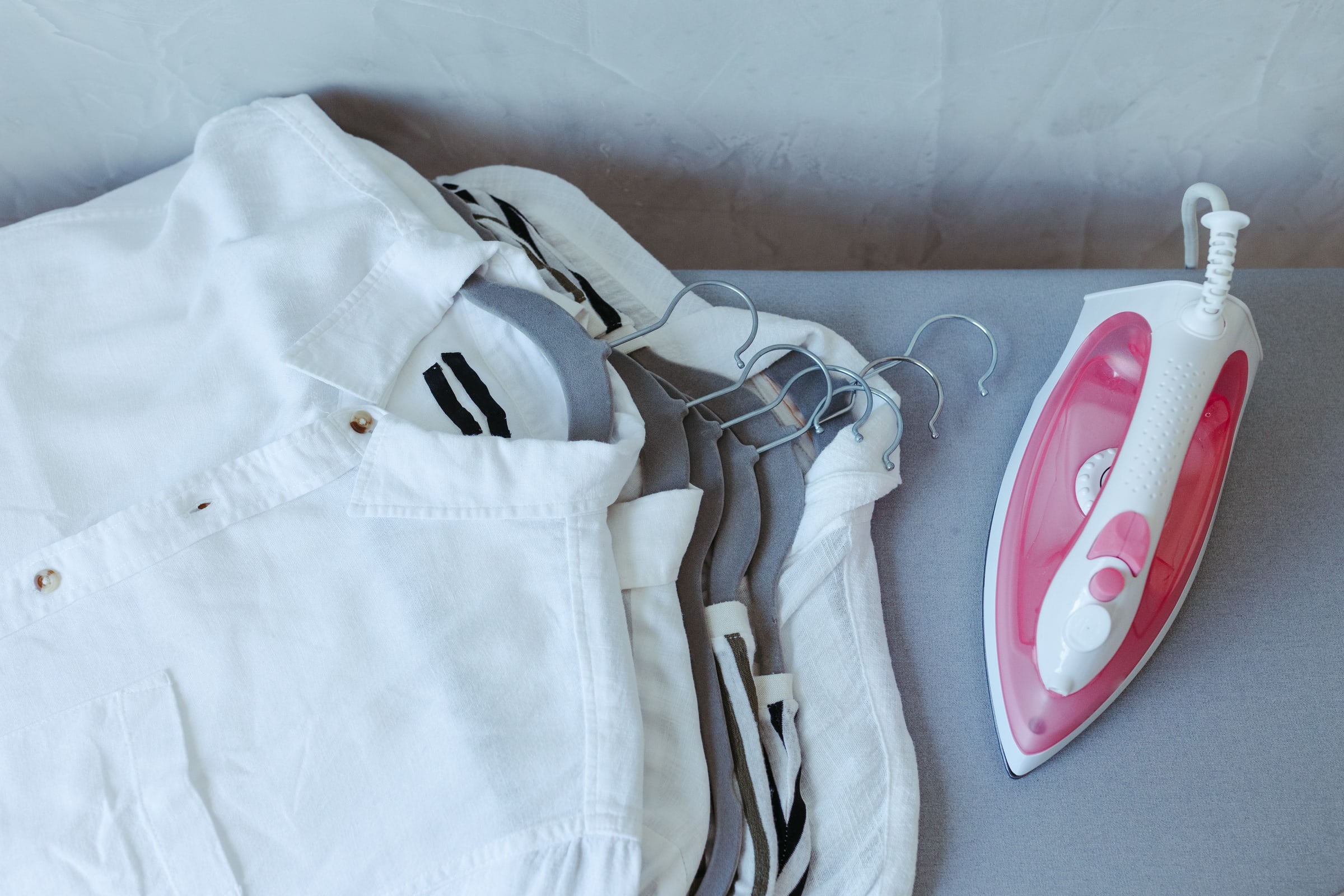 Pressed white shirts beside a steam iron